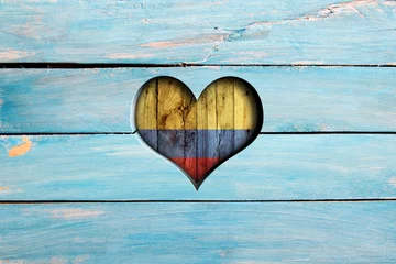 Fototapeten Love Colombia. Heart and flag on a blue wooden board © Zerophoto