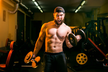 Fototapeta na wymiar man in gym training with dumbbells