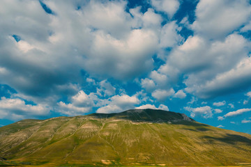 Castelluccio plateau with cloudy sky, Italy. Filtered image.