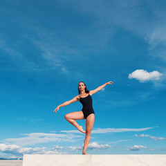 Fototapeta na wymiar Young beautiful ballerina dancing outdoors in a modern environme