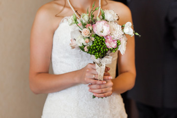 Bride holding wedding bouquet with decor