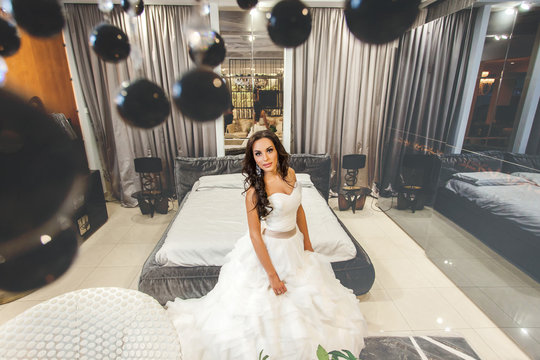 Bride In White Wedding Dress Sitting On Bed