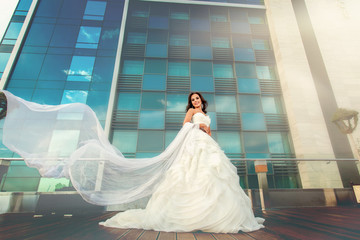 Woman bride in wedding dress and modern building