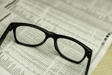 Glasses on newspaper. Macro view