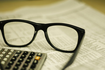 glasses and calculator on newspaper