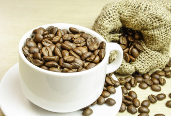 Cup with coffee beans, close up