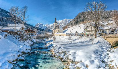 Idyllic mountain winter landscape with famous church and crystal clear river in Ramsau, Berchtesgadener Land, Bavaria, Germany