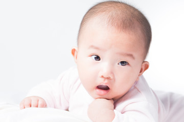 Adorable Asian baby 4-5 months old on white bed & background. Portrait studio light isolated.