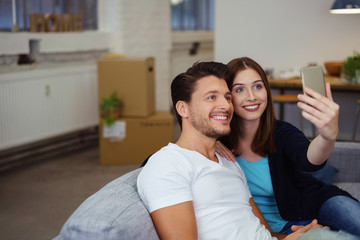 glückliches paar macht ein selfie nach dem umzug in die neue wohnung