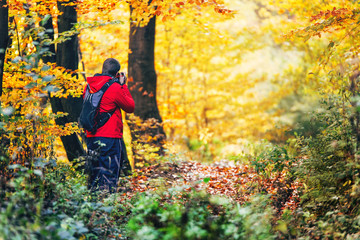 Hiker taking a photo of beautiful autumn sunset