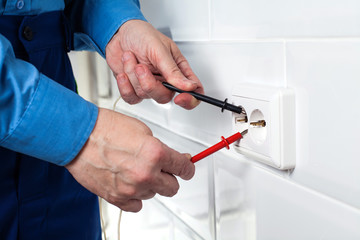 Electrician repairing socket in the house