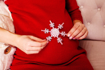 Anticipation, Pregnant woman with Christmas decoration - snowflake