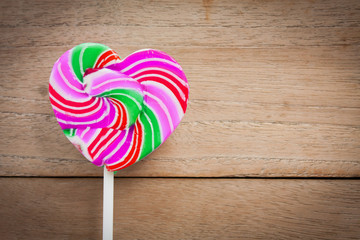 colorful heart lollipop on wood background