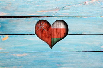 Love Oman. Heart and flag on a blue wooden board