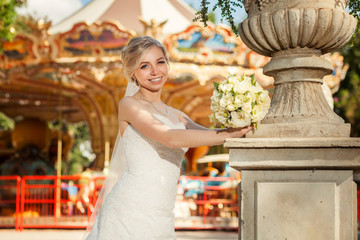 Female with bouquet near sculpture in park