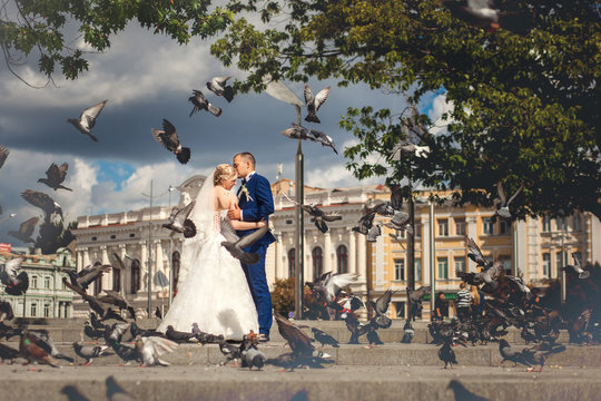 Husband and wife near building with doves