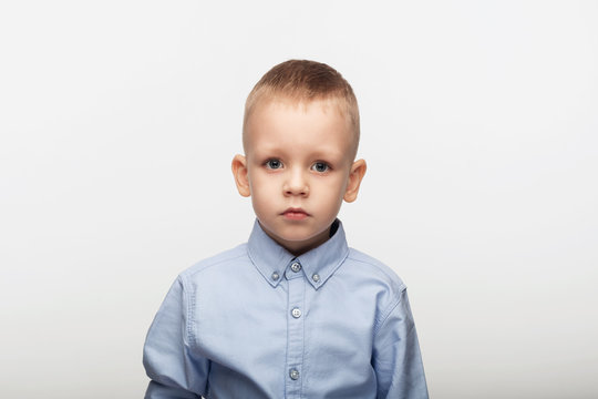 Portrait of a sad little boy in front of white background