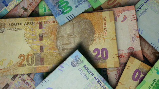 An extreme close up pan of a pile of randomly scattered south african rand banknotes