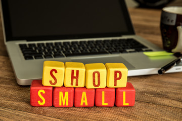 Shop Small written on a wooden cube in front of a laptop