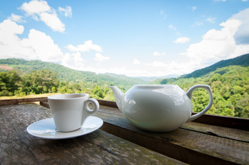 coffee cup on wooden with blurry nature background