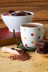 Hot chocolate drink next to bowl with sweets