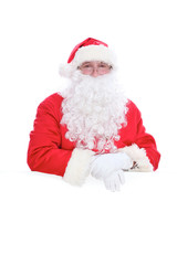 Kind Santa Claus looking out from behind the blank sign isolated on white background with copy space