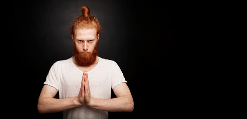 Portrait of handsome bearded ginger man standing, isolated on back background.
