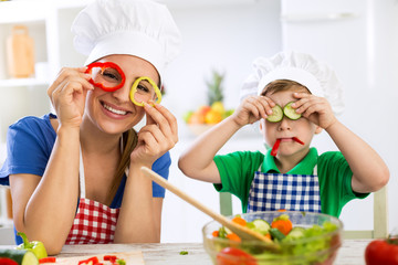 Happy cute family have fun in the kitchen with vegetables