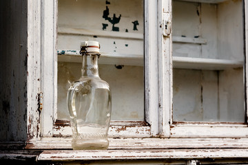 empty glass bottle on an old kitchen cabinet