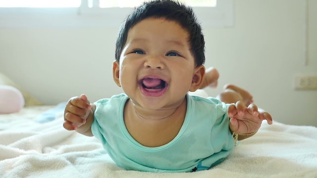 Asian baby (5 month after born) smile and laughing slow motion in bedroom