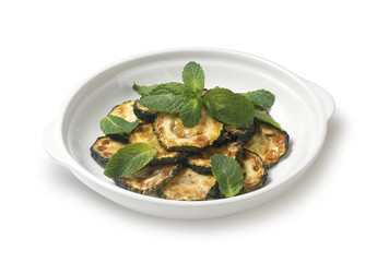 Sauteed zucchini with mint leaf on a white background