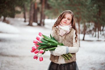 smiling birthday child girl with flowers in winter forest