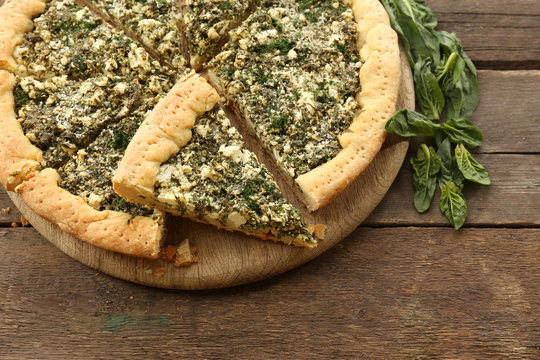 Slices of open pie with spinach on table close up