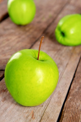 Ripe green apples on wooden table close up