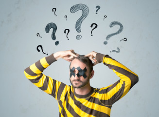 Young man with glued eye and question mark symbols