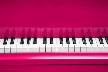 Piano keys of pink piano close up