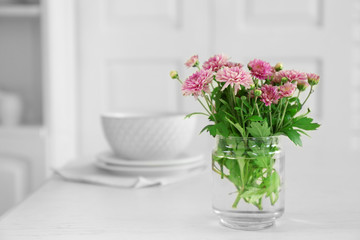 Obraz na płótnie Canvas Beautiful flowers in vase on table, on light background