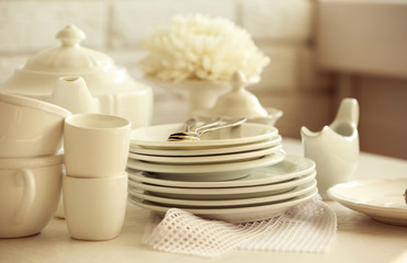 Clean dishes on table on brick wall background