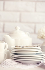 Clean dishes on table on brick wall background
