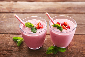 Fresh strawberry yogurt with mint on wooden background