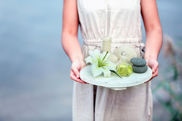 Female hands with tray of spa products, outdoors