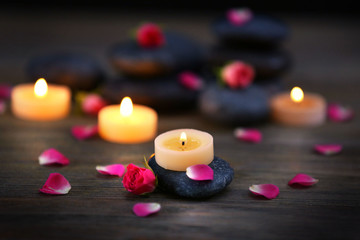 Spa stones and candles on dark background