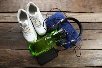 Headphones and sport equipment on old wooden background