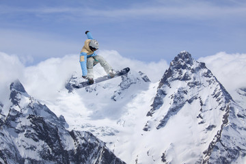 Fototapeta na wymiar Flying snowboarder on mountains, extreme sport