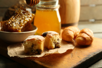 Honeycombs on plate, hot buns on wooden background