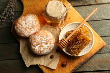 Honeycombs on plate, hot buns on wooden background