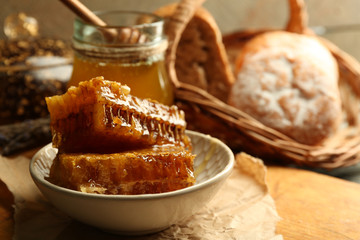 Honeycombs on plate, hot buns on wooden background