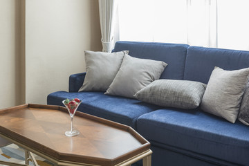 luxury blue sofa with grey pillows and wooden table