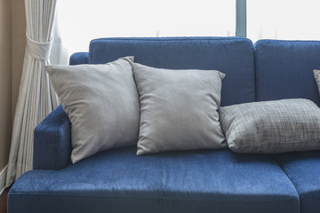 grey pillows on classic blue sofa