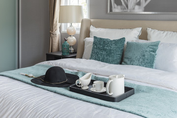 black hat on green blanket on bed in luxury bedroom